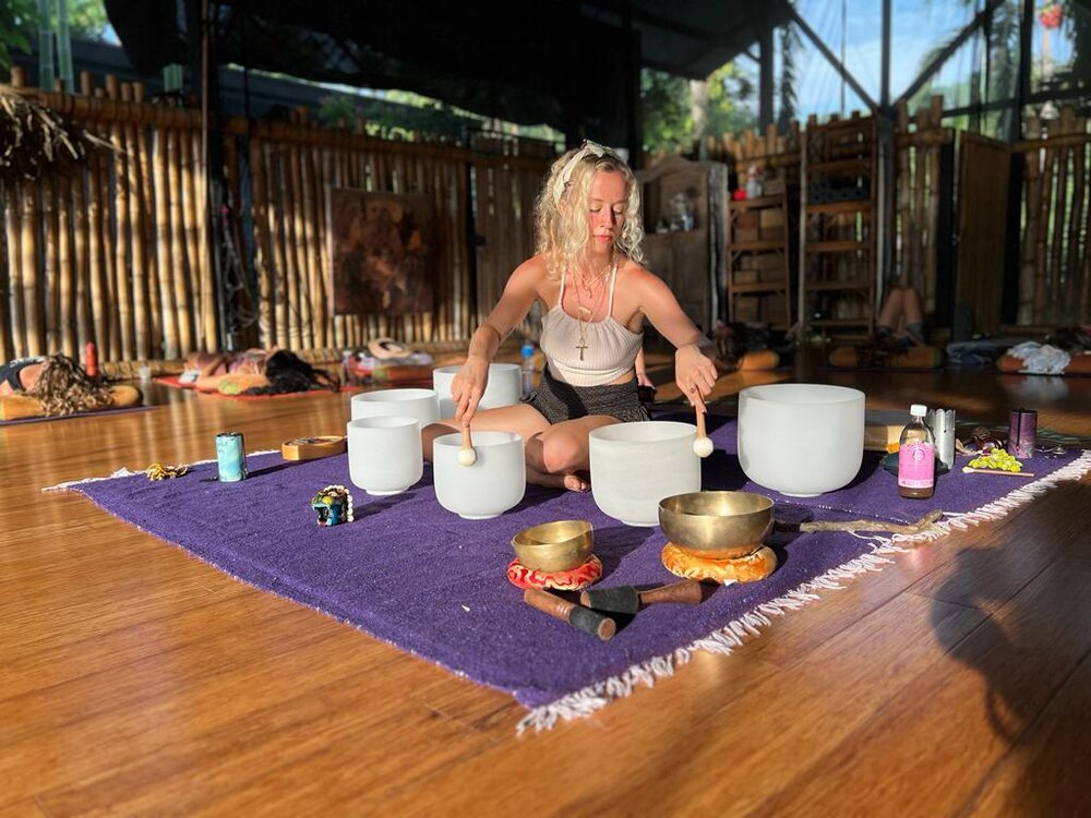 Sound healing session with singing bowls arranged on a purple mat
